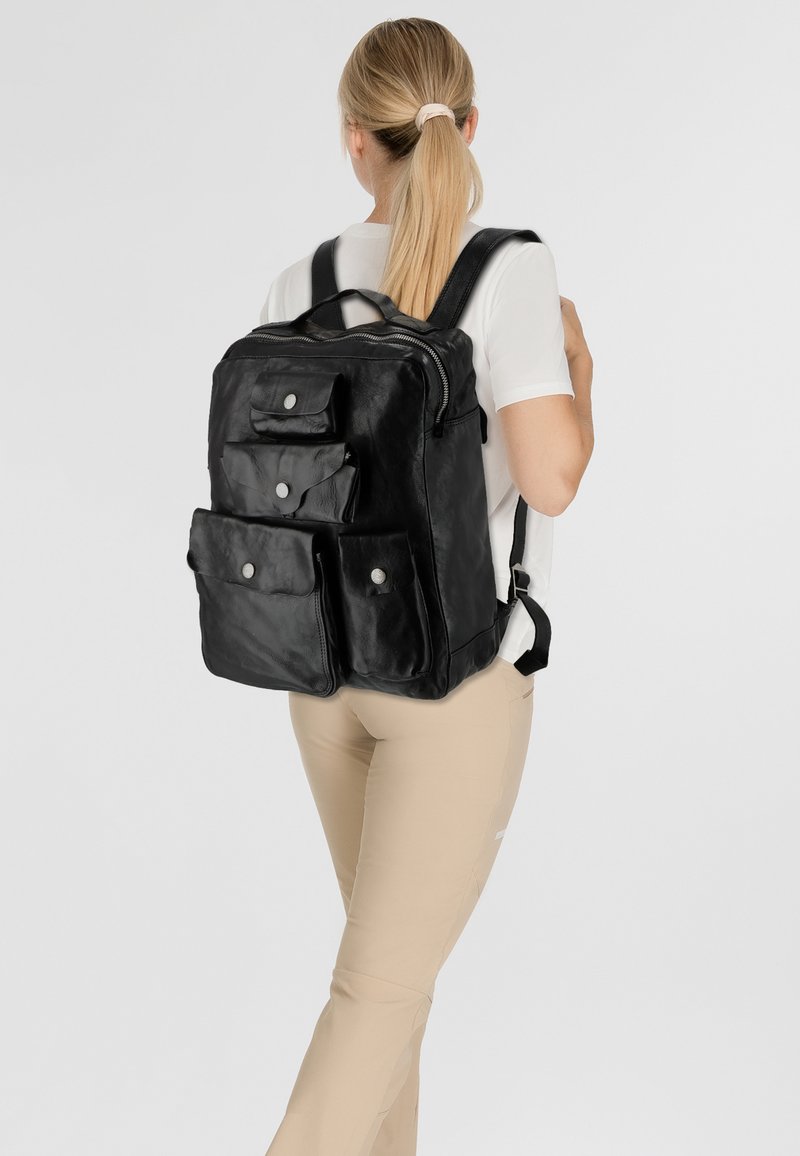 Zaino in pelle nera con tre tasche frontali dotate di chiusure a scatto, spallacci regolabili e una maniglia superiore per una comoda portabilità.