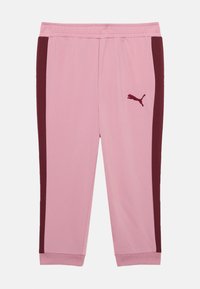 Roze trainingsbroek met bordeauxrode zijstrepen, een elastische tailleband en boorden. Bevat een klein geborduurd logo op de linkerdij.