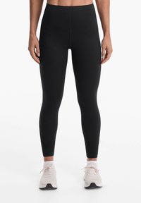Colanți negri dintr-un material elastic, cu un design cu talie înaltă, silueta ajustată, cu o textură netedă și fără modele sau accente vizibile.