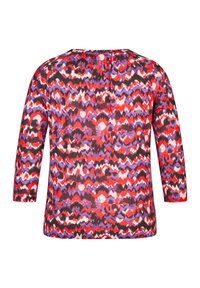 Multifarbene Bluse mit einem wellenförmigen Muster in Rot, Lila und Schwarz; lange Ärmel und ein runder Ausschnitt mit gerafften Akzenten im Rücken.