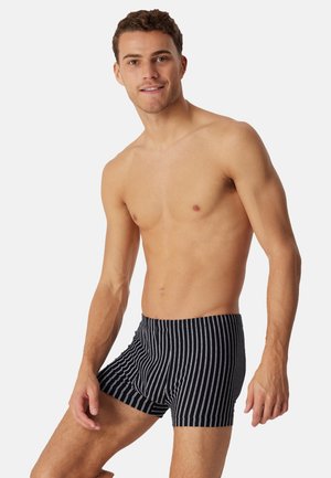 Boxer a righe nere con tessuto morbido. Dotati di fascia elastica in vita e taglio aderente. Le righe sono sottili e uniformemente distanziate.