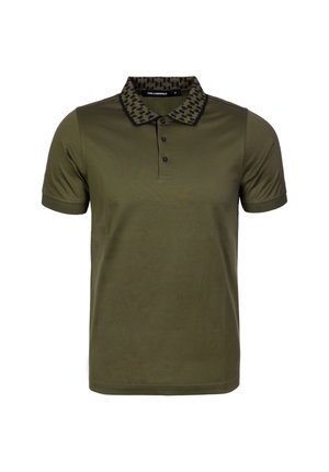 Olivgrön pikétröja med svart halsringning i hundtandsmönster, öppning med fem knappar och korta ärmar. Mjukt tyg i bomullsblandning.