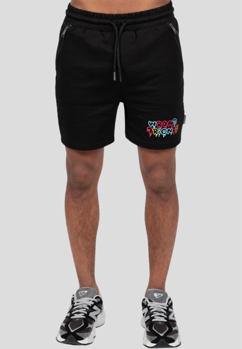 Schwarze Baumwollshorts mit einem elastischen Bund, versehen mit einem bunten "WRONG FRIENDS"-Grafik auf dem linken Bein und mit Reißverschlusstaschen an den Seiten.