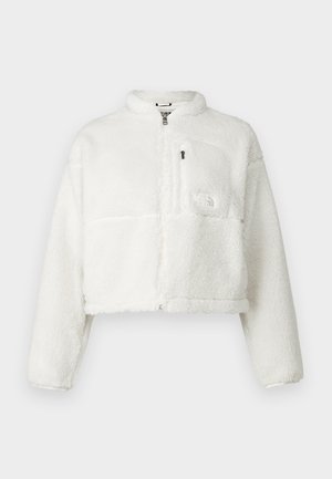 Weißer, kurzer Fleece-Jacke mit hohem Kragen, durchgehendem Reißverschluss und Logopatch auf der Brusttasche. Weiche Textur, lange Ärmel und lässige Passform.
