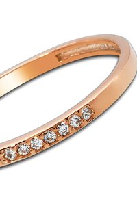 Anneau à bande en or rose présentant une surface lisse avec sept petits pierres précieuses claires et rondes disposées en ligne le long d'un côté.