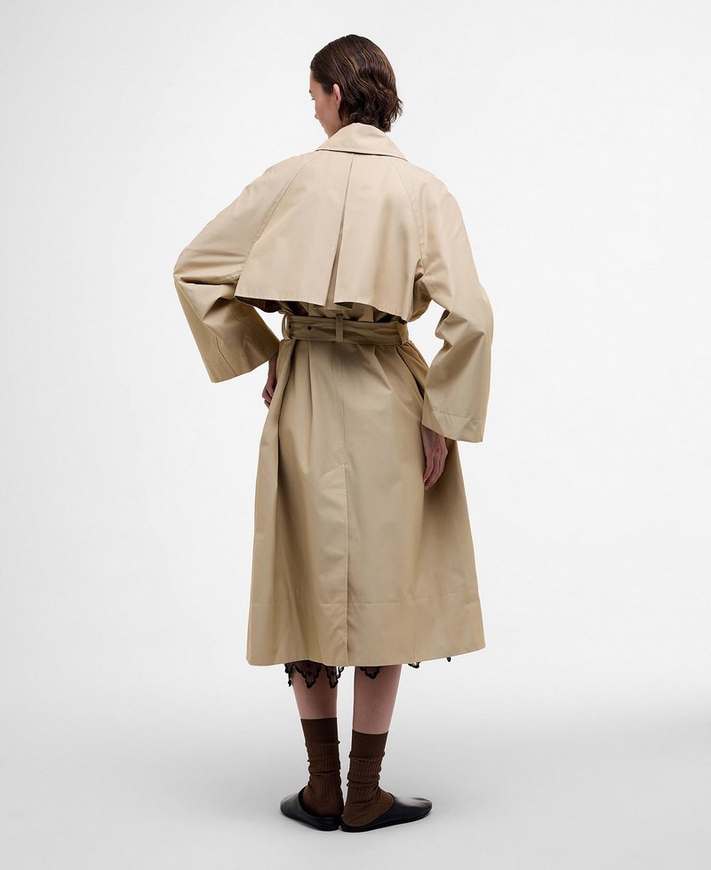 Beiger Trenchcoat mit weiten Ärmeln und tailliertem Bund, mit einem kurzen rückseitigen Design und glatter Textur. Das Modell trägt ein Kleid aus Spitze darunter.