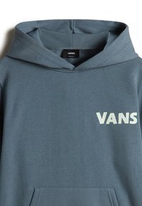 Sudadera con capucha en tejido azul-gris, con un bolsillo frontal y un logo blanco de "VANS" en el pecho. Textura suave y diseño informal.