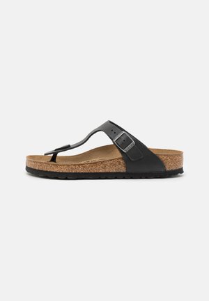 Black thong sandal with a cork footbed, adjustable strap with a metal buckle, and textured rubber outsole. Flat design with a minimalist look.