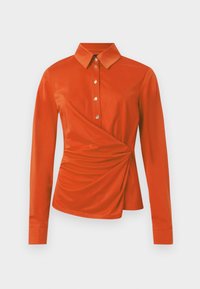 Chemise rouge à manches longues avec col, dotée d'une fermeture boutonnée à l'avant, d'une texture froncée sur le côté et de boutons de couleur dorée.