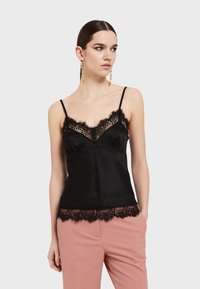 Černý saténový tílko s krajkovým lemem kolem výstřihu a spodního okraje, s nastavitelnými ramínky a přiléhavým střihem.