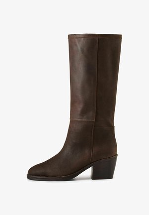 Rudos odinės iki kelių botai su apvaliu nosiu, sustiprintu kulnu ir minimaliais siūlės. Lygi tekstūra su matinio paviršiaus apdaila.