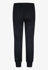 Sorte joggingbukser med en blød tekstur, der har en elastisk talje og smalle manchetter for en tætsiddende pasform. Ingen synlige logoer eller mønstre.