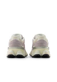 Μωβ και εκρού αθλητικά παπούτσια με υφή στην επιφάνεια, επενδεδυμένη σόλα και ανακλαστικές λεπτομέρειες. Στρογγυλεμένο σχήμα, μαύρη εξωτερική σόλα από καουτσούκ.