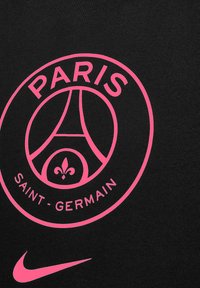 Schwarzes T-Shirt mit einem pinkfarbenen, runden Logo, das den Schriftzug "PARIS SAINT-GERMAIN" und ein Design des Eiffelturms enthält. Mit pinkem Nike-Swoosh.