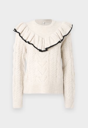 Pull en crème tricoté avec un motif en relief, des poignets côtelés et un col à volants bordé de noir. Manches longues, col rond, tissu texturé.