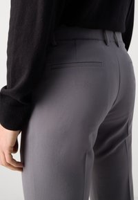 Gray trousers made of lightweight fabric, featuring a smooth texture, straight leg design, and a back pocket with a subtle seam detail.