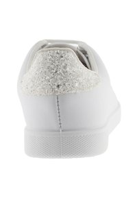 Vit sneakers med en texturerad gummisula, slät syntetisk ovandel och en glittrig vit detalj på hälen. Har enkla sömnadsdetaljer.