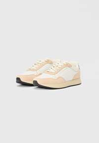 Αθλητικά παπούτσια με συνδυασμό λευκού και ανοιχτού ροδακινί σουέντ και πλέγματος, σχέδιο με κορδόνια και μαύρη καουτσούκ σόλα. Χρυσό λογότυπο στη πλευρά.