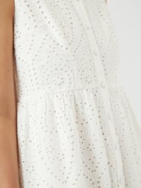 Rochie albă din țesătură cu boruri, prezentând modele intricate, închidere frontală cu butoane și un corset ajustat ce trece într-o fustă evazată.