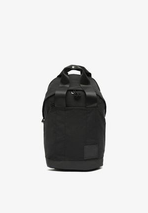 Black duffel bag with dual handles, zip closure, and a small patch on the lower front against a white background.