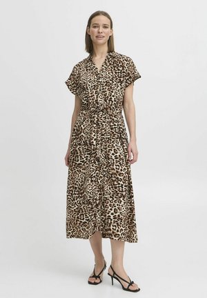 Maxiklänning med leopardmönster i lätt tyg, med korta ärmar, midja med dragsko och flödande silhuett. Svarta remsandaler.