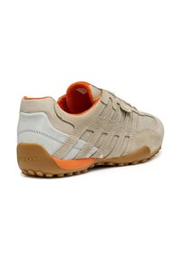 Beżowe zamszowe sneakersy z szarymi akcentami. Posiadają teksturowaną cholewkę, pomarańczowe wnętrze oraz elastyczną podeszwę z małymi wypustkami antypoślizgowymi. Widoczne logo Geox.