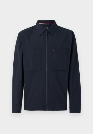 Mornarsko zip-jersey s širšim ovratnikom, dvema sprednjima žepoma in malim logotipom na levem žepu. Gladka tekstura, dolgi rokavi.