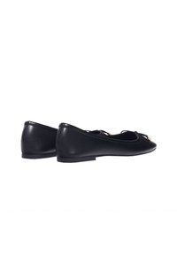 Ballerines noires en cuir avec une finition lisse, bout rond, design minimaliste et un accent en nœud �à l'avant. Semelle plate.