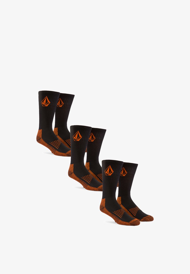 Trois paires de chaussettes mi-hautes noires avec talons, orteils et logo orange, disposées en rangée décalée sur un fond blanc.
