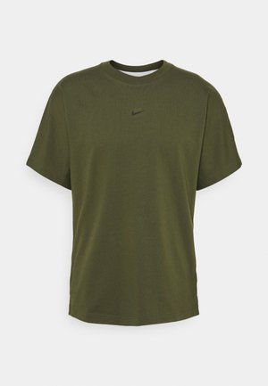 Olive green cotton T-shirt with a crew neck, short sleeves, and a small black Nike logo on the front. Smooth texture, relaxed fit.