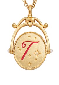 Gouden medaillonhanger met een rode "T," versierd met sterren en kralen. Gedetailleerde gravure met een gepolijste afwerking en decoratieve accenten.