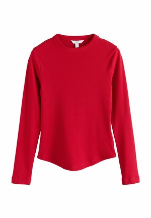 Chemise en coton rouge à manches longues, côtelée, col rond et ourlet légèrement asymétrique.