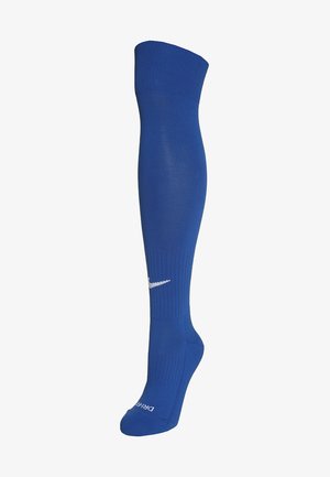 Sinine põlve kõrgune sokk, mis on valmistatud venivast materjalist, millel on valge Nike logo ja ribide tekstuur ülemisel osal mugavuse ja haakimise tagamiseks.