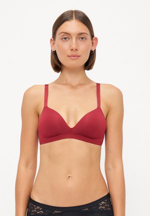 Red bralette with a smooth finish, triangle cups, thin adjustable straps, lightweight fabric, and minimal seams for comfort.