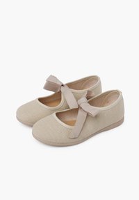 Zapatos de ballet de lona beige con una superficie texturizada, puntera redonda y un lazo decorativo en cada zapato. Suela plana y flexible para mayor comodidad.