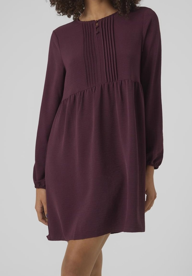 Kurzärmliges, knielanges Kleid in tiefburgunder mit Falten an der Passe und Knopfdetails am Ausschnitt. Glatte Textur, lockere Passform.