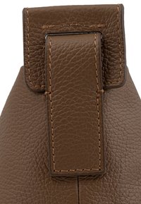 Cuero marrón texturizado con una solapa rectangular grande y un detalle de costura en contraste, exhibiendo un sutil patrón en relieve.