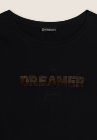 T-shirt nera in cotone con scollatura rotonda e testo decorato "the DREAMER" in borchie arancioni e dorate, con "freddy" scritto in una calligrafia discreta.