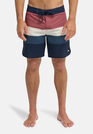 Férfi úszónadrág színblokkolt dizájnnal, piros, krém, kék és tengerészkék színekben. Könnyű anyagból készült, elasztikus derékrésszel és húzózsinórral.