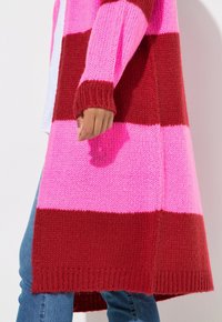 Cardigan a maglia con ampie strisce orizzontali rosse e rosa, polsini a costine e un orlo leggermente allungato per una maggiore copertura e calore.