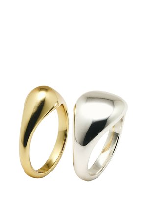 Due anelli lisci e lucidati con un design moderno curvo, uno oro e uno argento, mostrati affiancati su uno sfondo bianco.