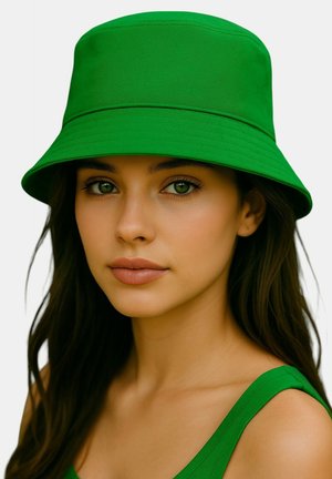 Sombrero tipo bucket verde hecho de tela, con ala ancha, textura suave y diseño estructurado, combinado con una camiseta verde a juego.