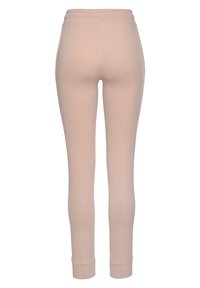 Dünne, elastische Leggings aus einem weichen, hellrosa Stoff. Mit hohem Bund und enganliegenden Bündchen an den Knöcheln. Glatte Textur, minimalistisches Design.
