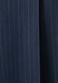 Tissu bleu foncé avec de fines rayures verticales blanches régulièrement espacées, montrant de légers plis et une texture.