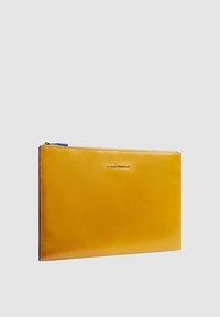 Funda para portátil de cuero amarillo con cremallera azul, forma rectangular, textura lisa y logo en relieve. Adecuada para dispositivos delgados.