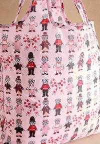 Rožinė rankinė su pakartotiniu iliustruotų personažų raštu, dėvinčių įvairius drabužius ir aksesuarus, kartu su taškuotais kaspinais.