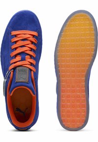 Niebieskie zamszowe niskie sneakersy z pomarańczowymi sznurówkami i wnętrzem. Posiadają teksturowaną gumową podeszwę przechodzącą z przezroczystej na pomarańczową. Akcent w postaci metalowej tabliczki.