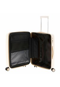Valigia rigida color crema con manico estraibile, tasche in rete interne e cinghie di compressione; rivestimento in tessuto nero con dettagli a motivo.
