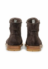 Stivali alla caviglia in suede marrone con punta arrotondata, cuciture decorative e due bottoni sul lato. La suola è realizzata in gomma chiara.