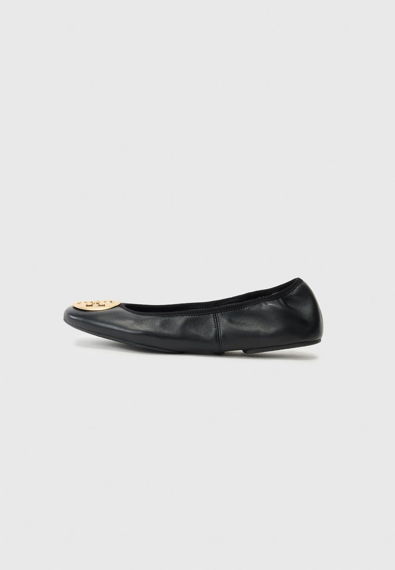 Ballerine en cuir noir avec un bout arrondi, présentant un accent en métal doré sur le bout, une texture lisse et une semelle flexible.